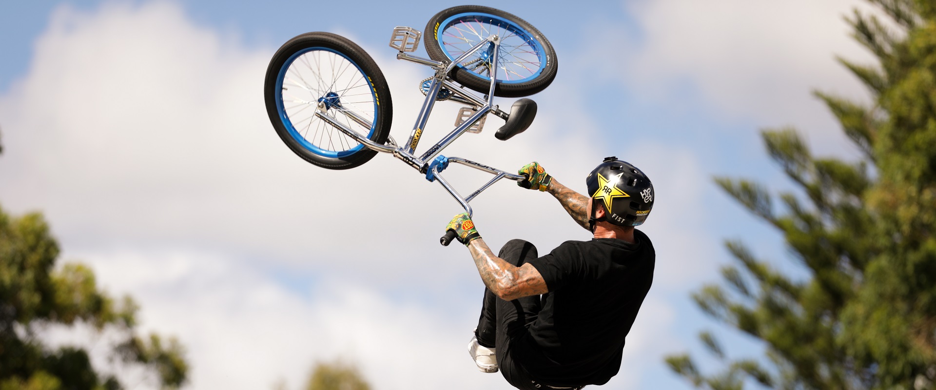 bmx athlete up high in the air holding on to his BMX